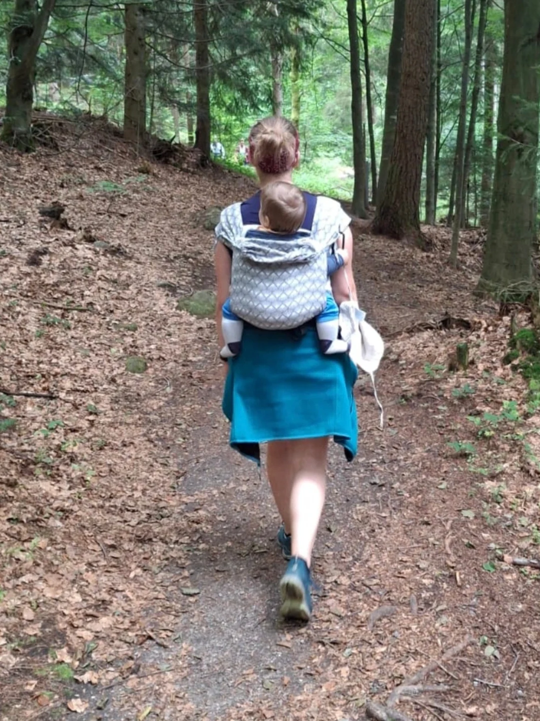 Kind sitzt in ergonomischer Babytrage auf dem Rücken - MonaS Trageberatung - Trageberaterin aus Lemgo, Detmold, Lippe, OWL und Umgebung